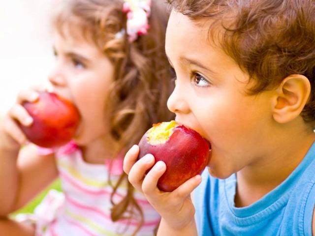 Niños comiendo manzanas