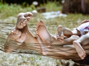 Pies de una familia tumbada en una hamaca