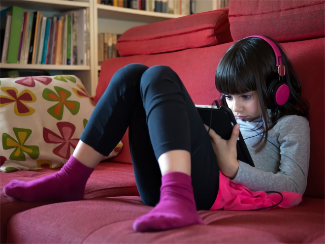 Niña con tablet en el sofa